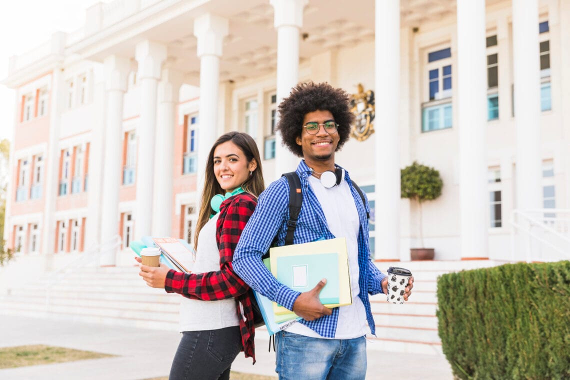 Dicas para pesquisar bem sobre faculdades e cursos 1 diversos jovem estudante masculino e feminino segurando livros e taca de cafe para viagem em pe na frente predio