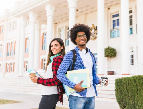 Dicas para pesquisar bem sobre faculdades e cursos 6 diversos jovem estudante masculino e feminino segurando livros e taca de cafe para viagem em pe na frente predio